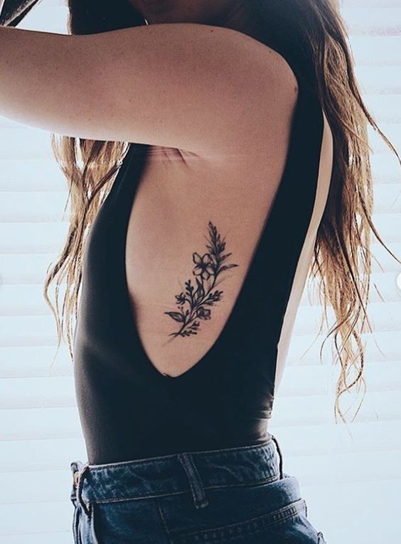 small flower rib tattoo idea 17