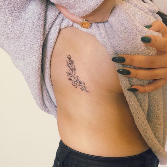 Minimalist flower rib tattoo 